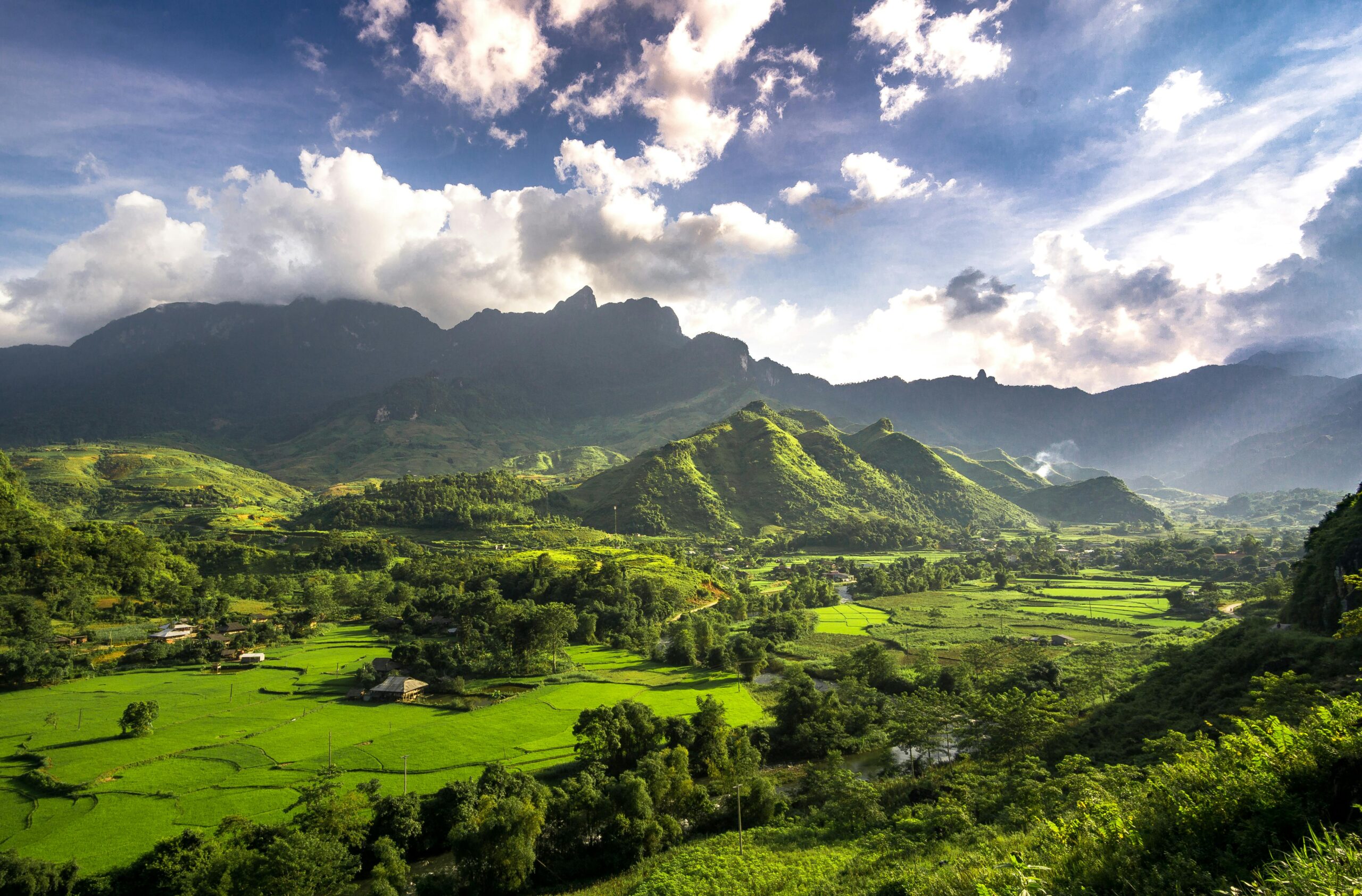 Explore the lush green landscapes and rolling hills of Hà Giang under cloudy skies.