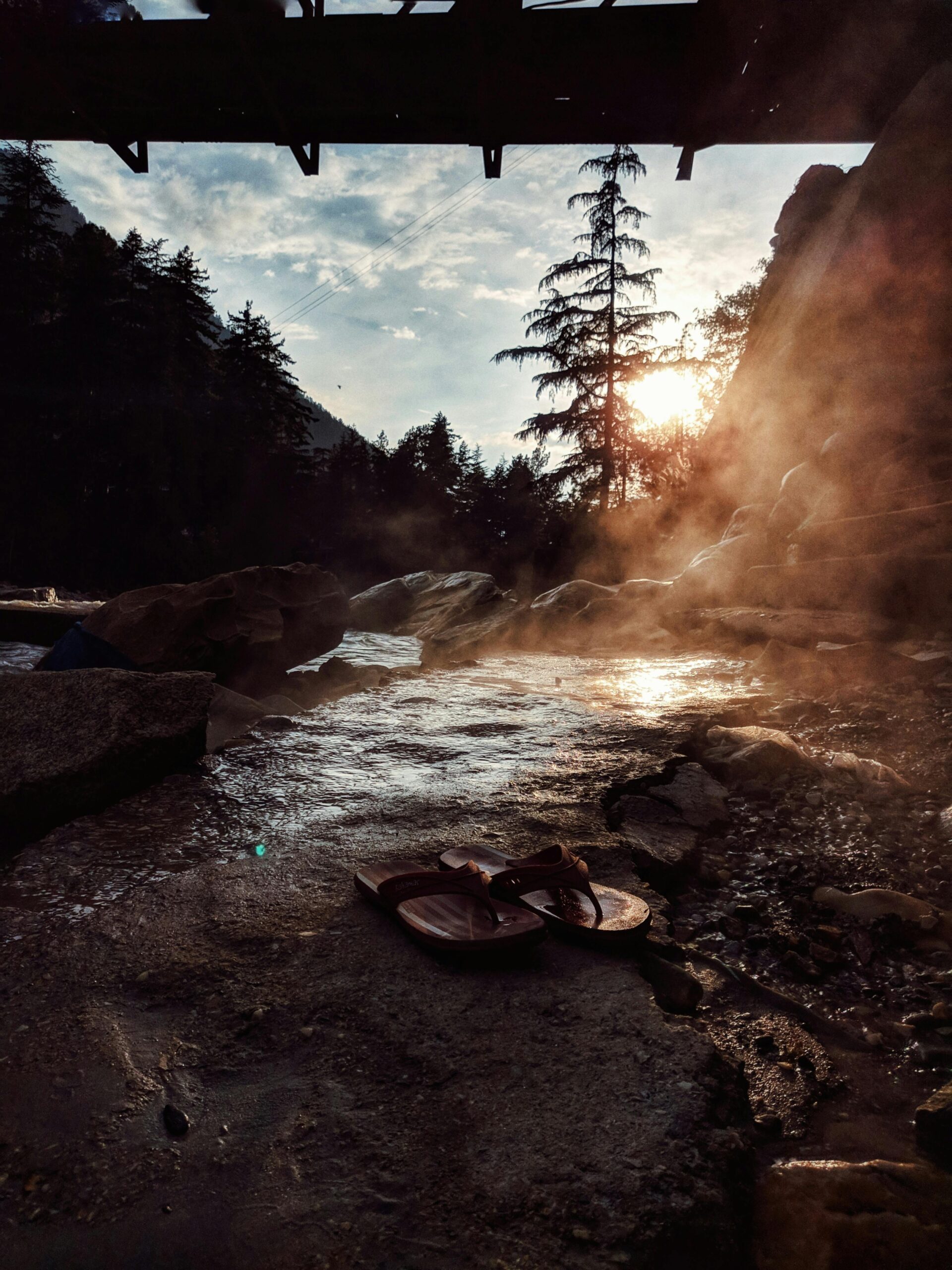 Capture of a tranquil sunrise over a rocky riverbank in Kasol, Himachal Pradesh, India.
