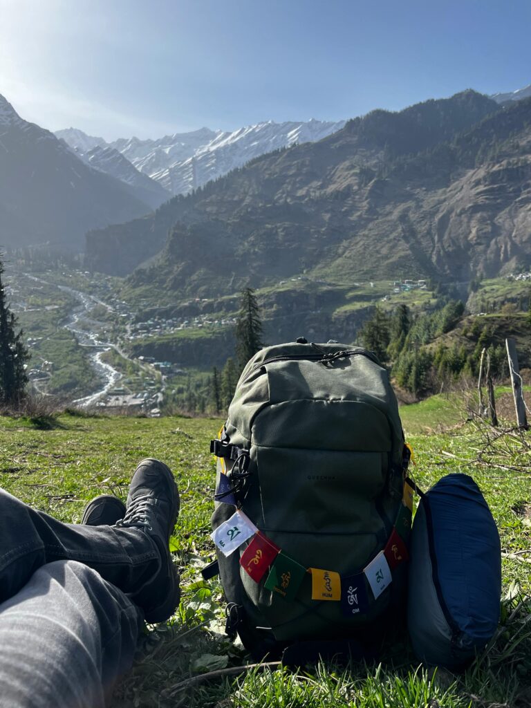 Relaxing with a backpack in Manali, HP, India with stunning mountain views.